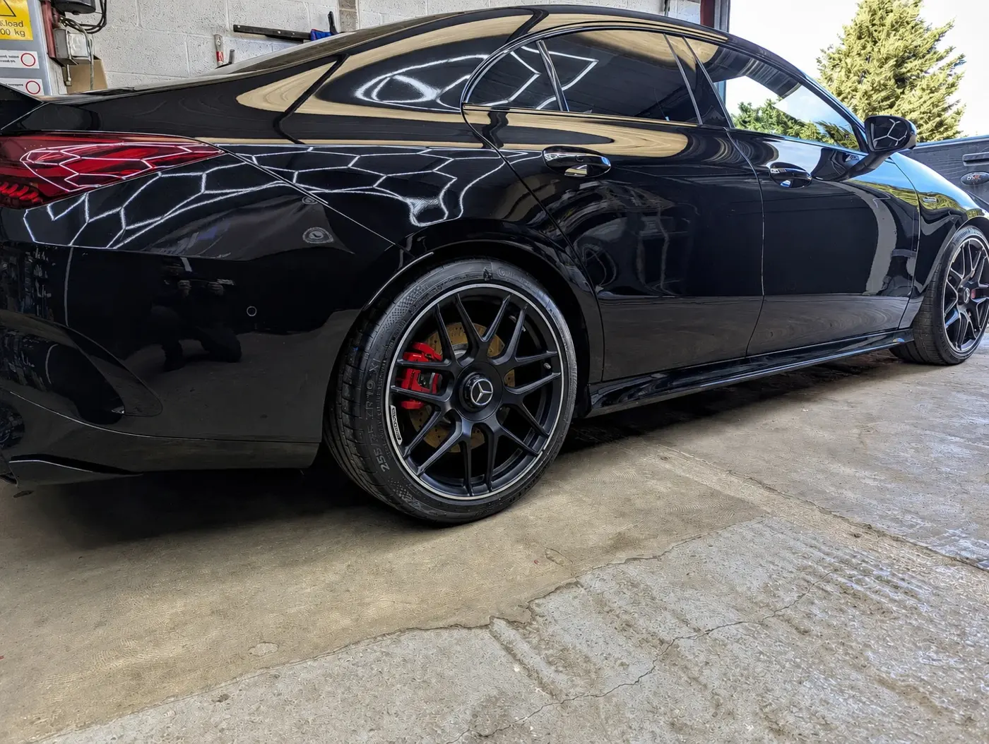 Black Mercedes-AMG after machine polishing at WK Detailing, Stratford-upon-Avon, with studio hex lights reflected in the paint