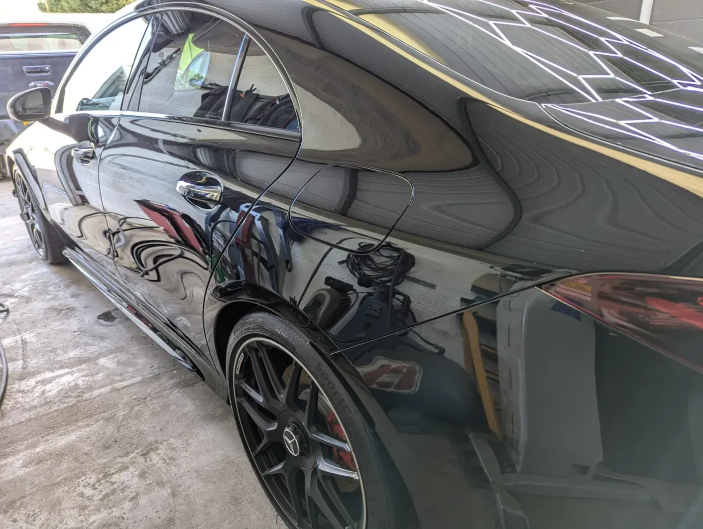 Machine polished black paintwork reflecting hex studio lights
