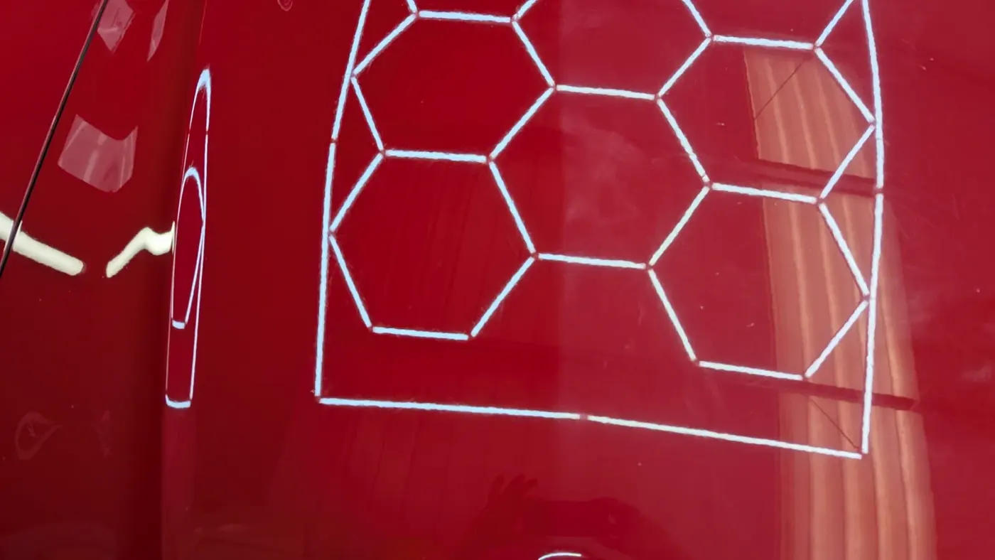 Red paintwork with hex light reflection after swirl removal